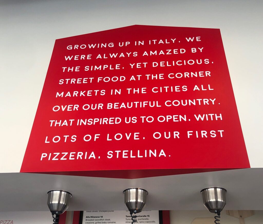 Red Store Sign that says "Our First Pizzeria. Stellina"